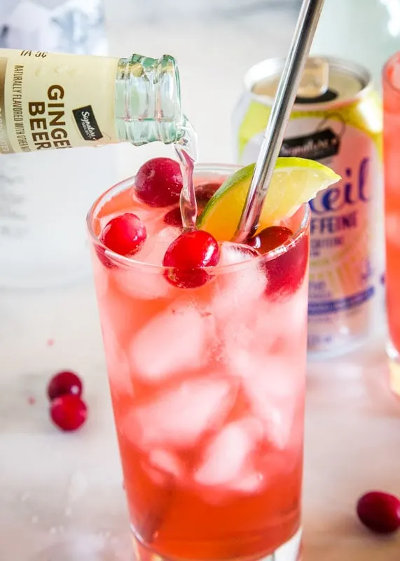 cranberry vodka spritzer with ginger beer being poured in