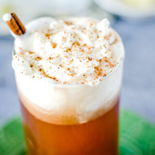 cropped image of hot buttered rum in glass with whipped cream