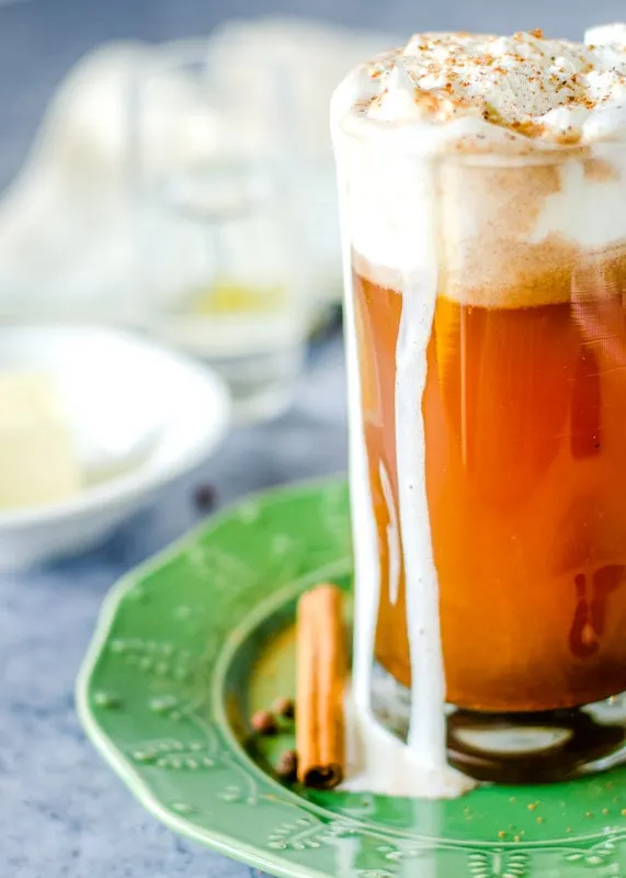 hot buttered rum in a glass on a green plate