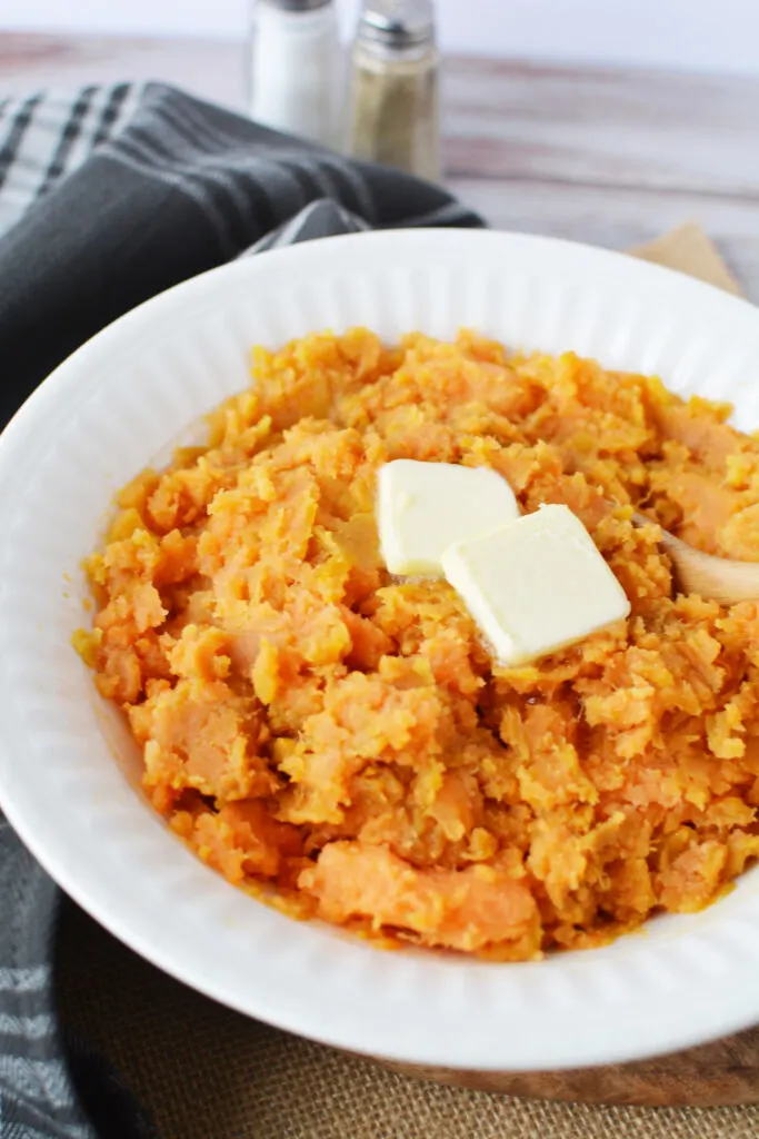 bowl of mashed sweet potatoes topped with butter