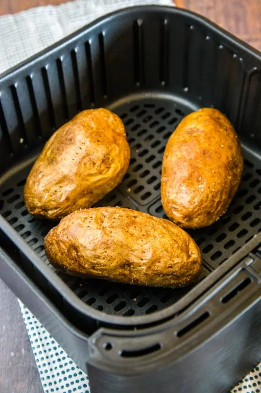 cooked baked potatoes in the air fryer basket