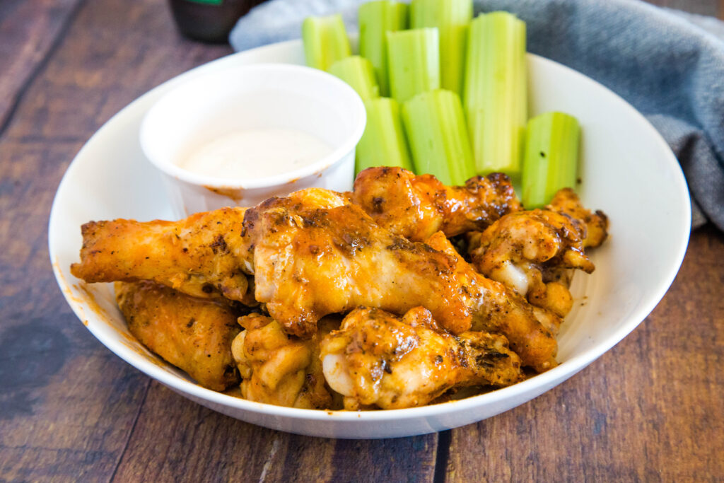 buffalo chicken wings on plate with celery sticks and ranch