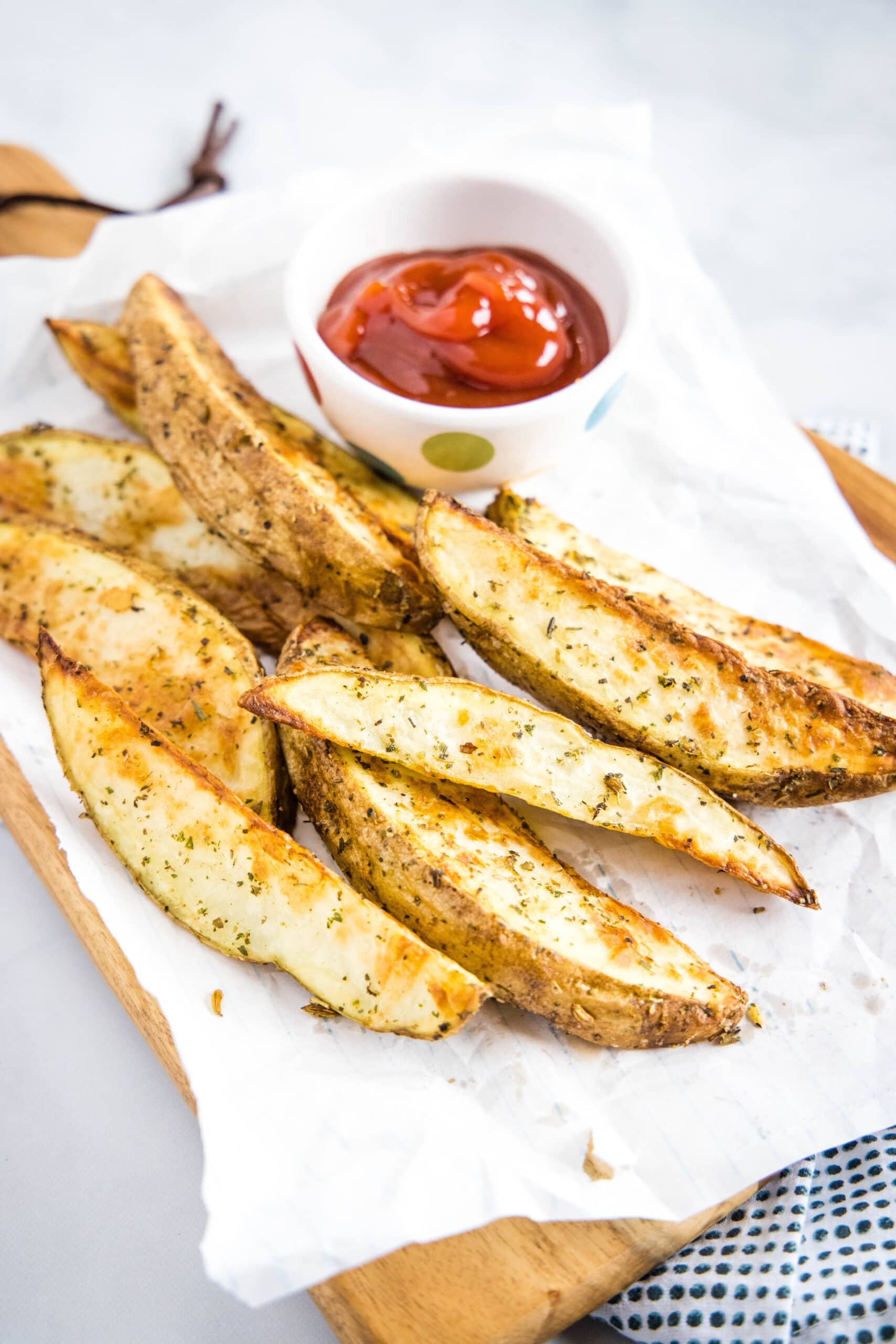 crispy potato wedges on board with ketchup