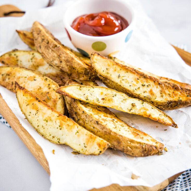 cropped picture of potato wedges with bowl of ketchup
