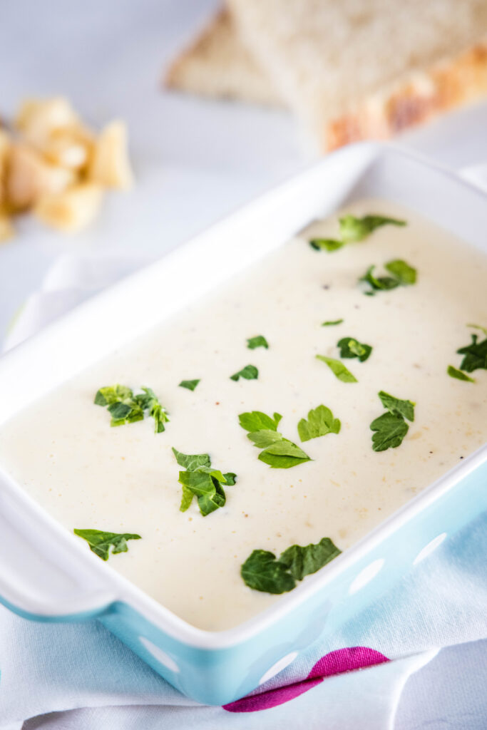 garlic cream sauce in a dish sprinkled with parsley