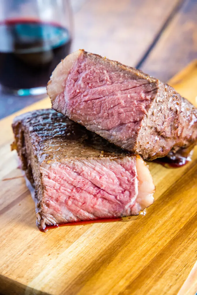steak cut in half on cutting boar