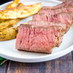 cropped sous vide cooked steak sliced on a plate