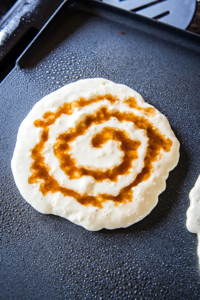 pancake on griddle with cinnamon swirl