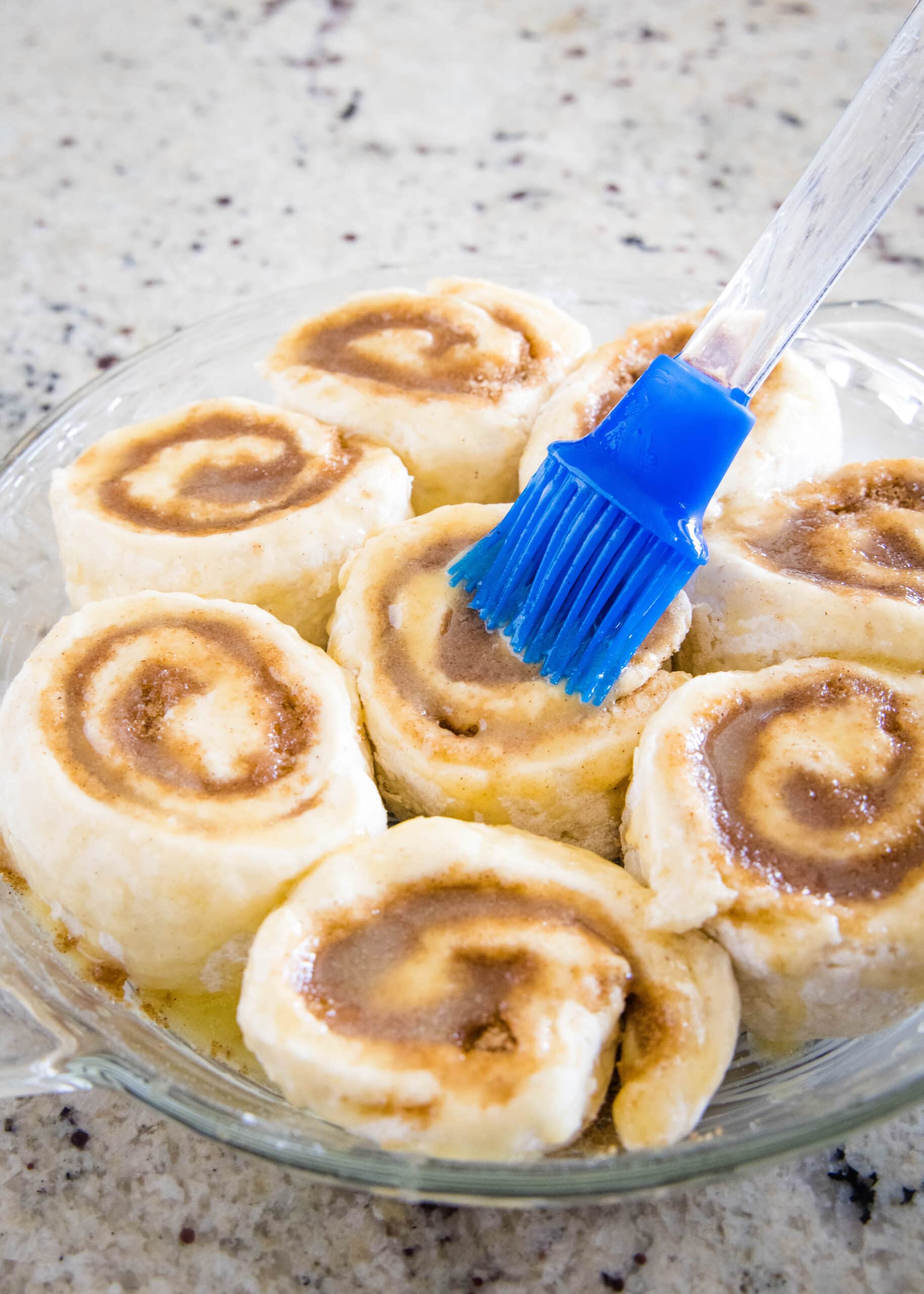 brush butter on cinnamon rolls in the pan