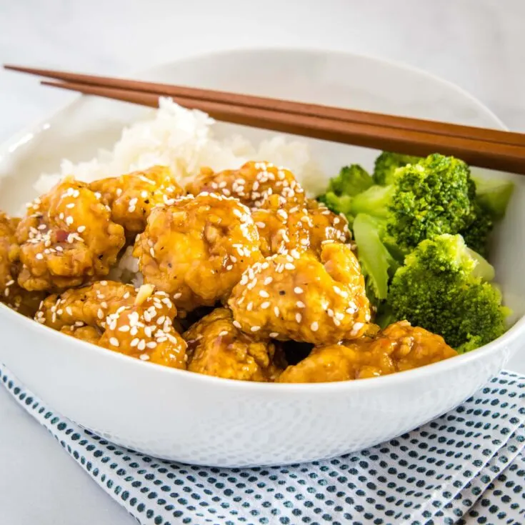 cropped sesame chicken picture with broccoli in white bowl