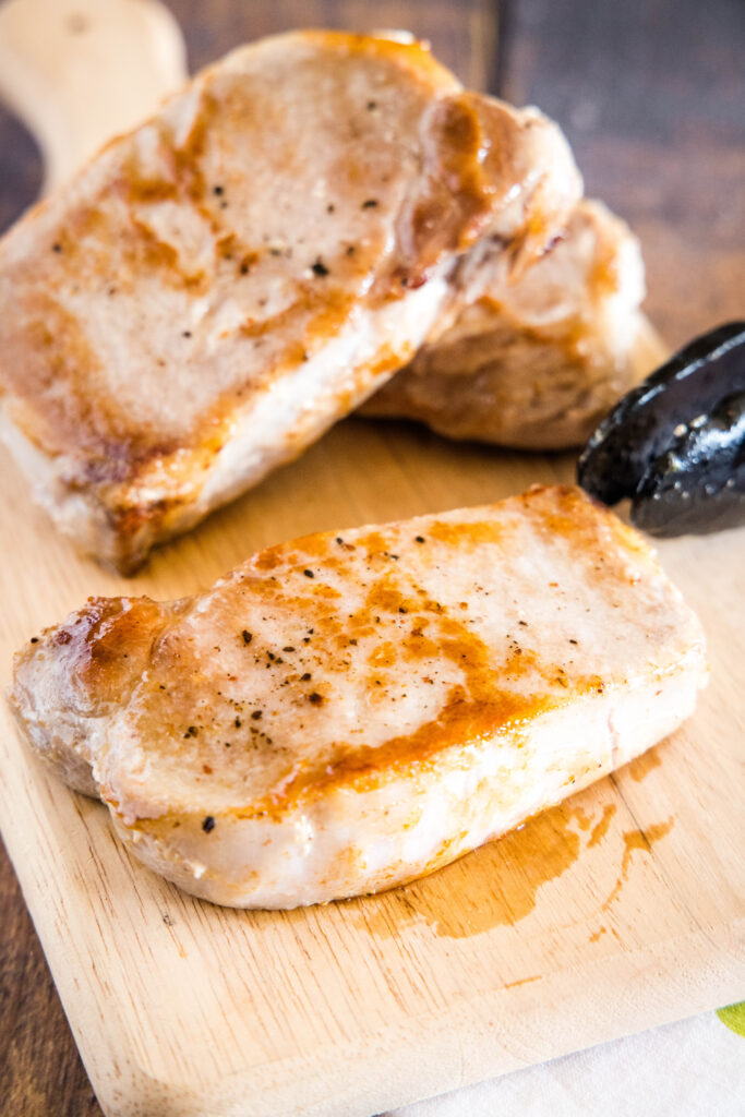 cooked pork chops on cutting board