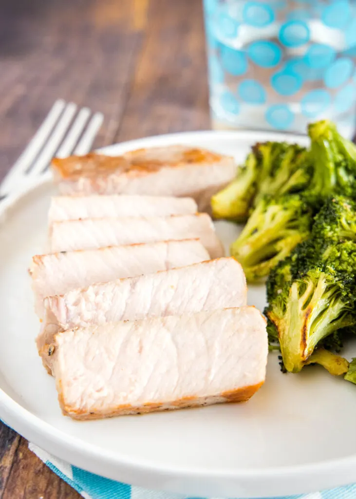 sliced pork chop on plate with broccoli
