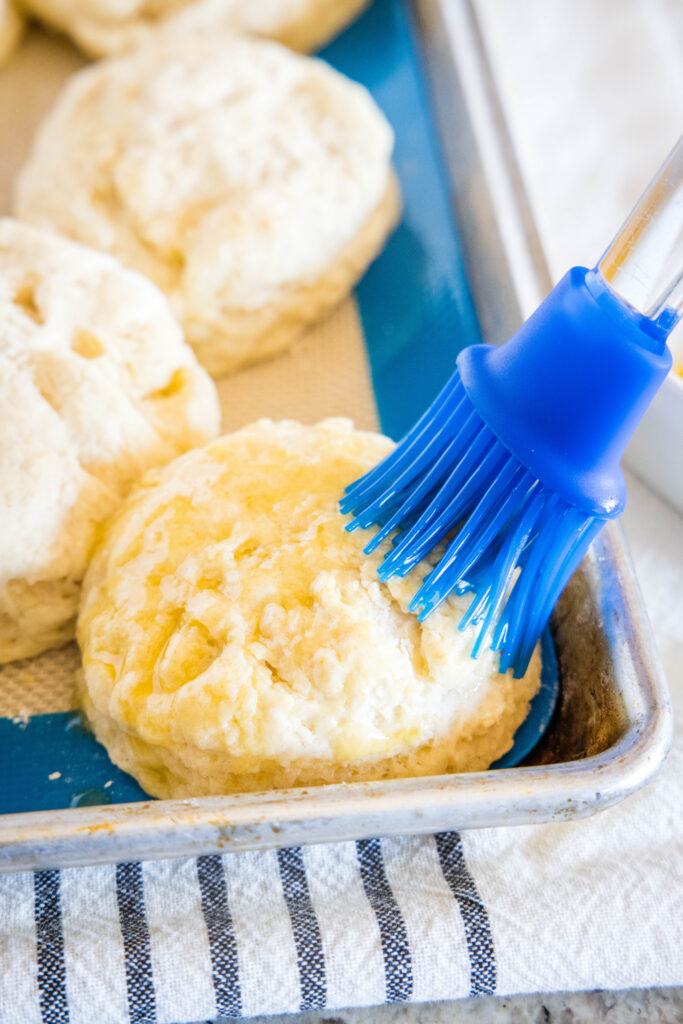 brushing butter on biscuits