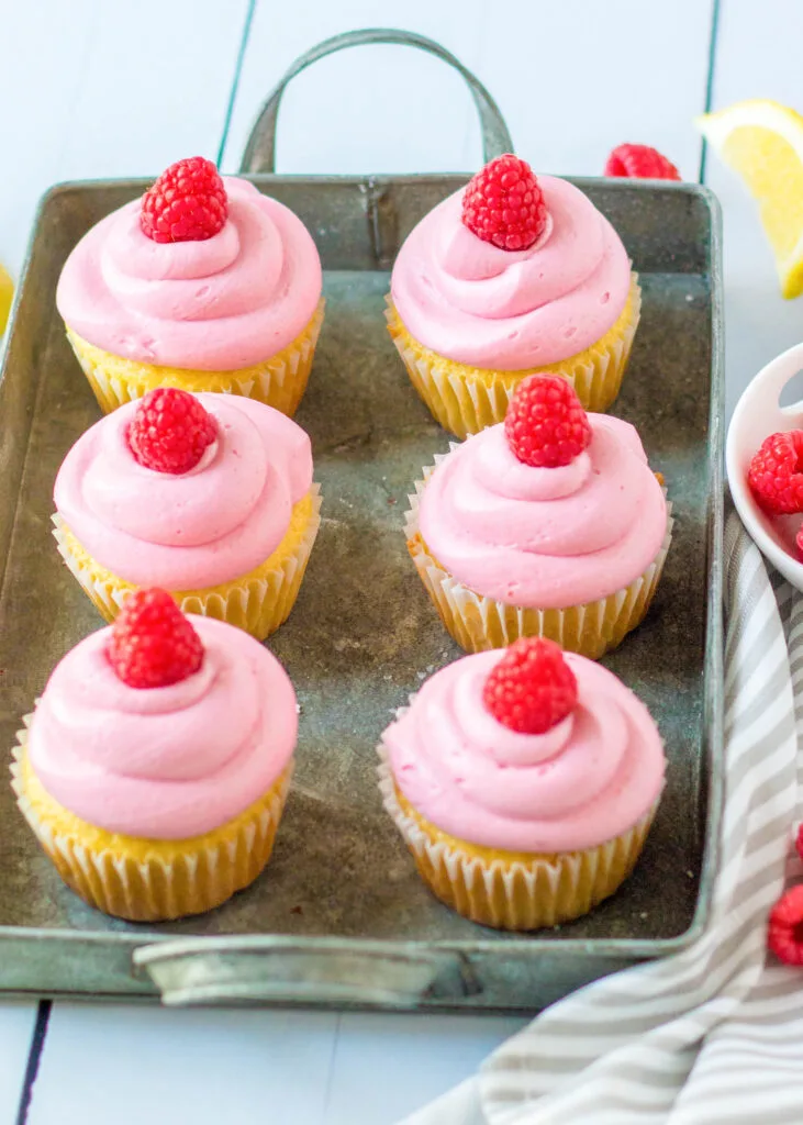 lemon cupcakes with raspberry frosting on a tray