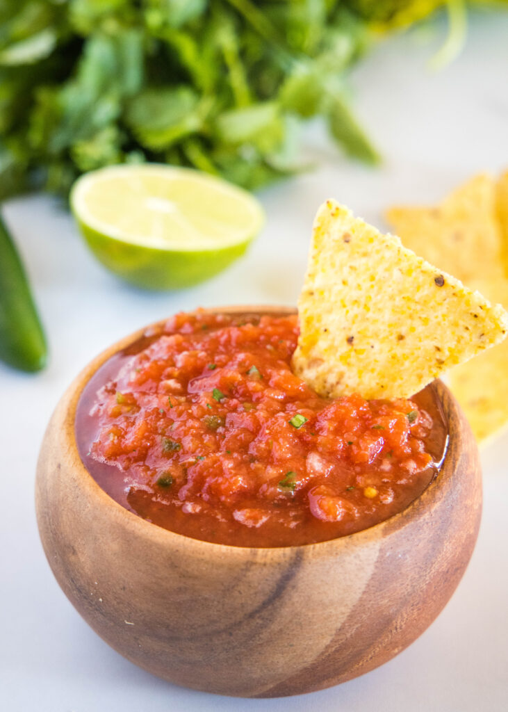 bowl of salsa with chip in it