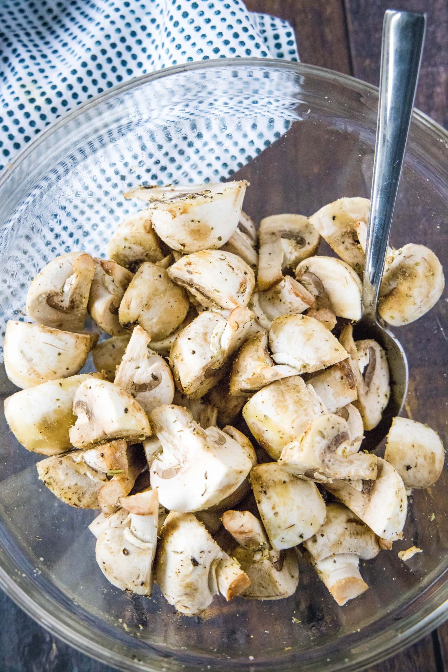 cut up mushrooms in a bowl with olive oil and spices
