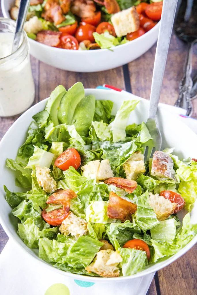 tossed blt salad in a bowl with fork