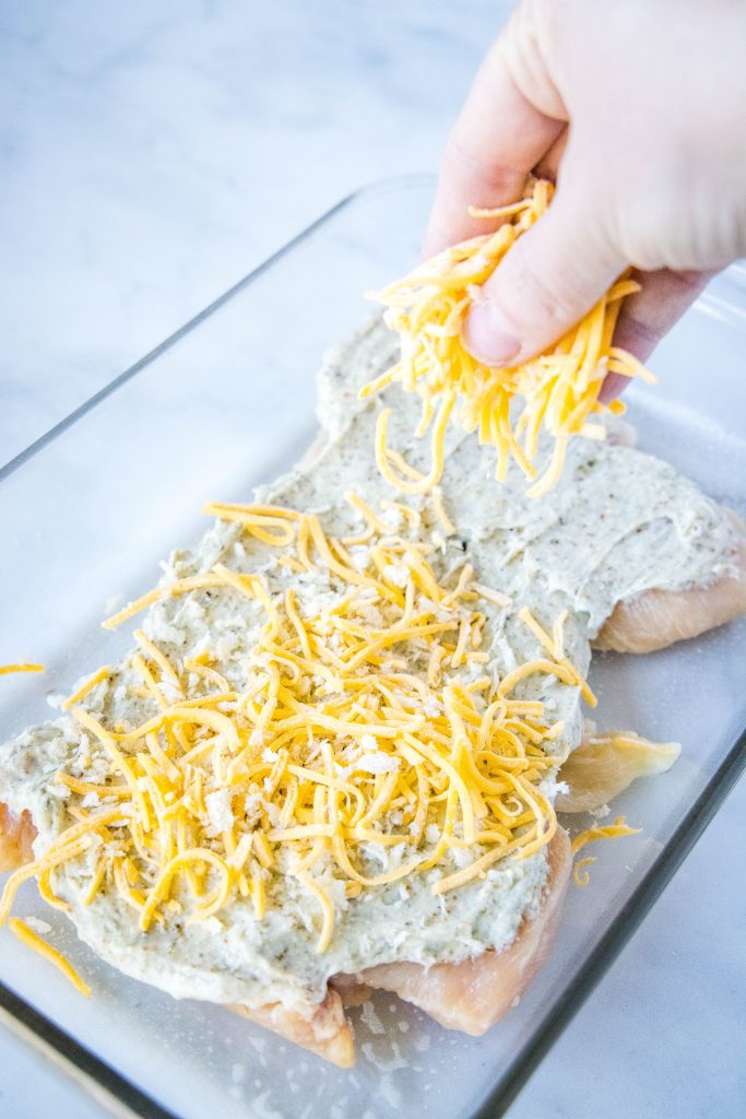 sprinkling breadcrumbs and cheese over chicken