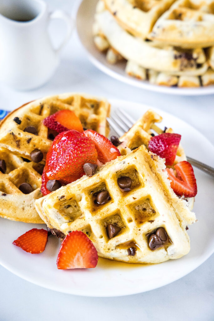 pieces of waffles on plate with strawberries