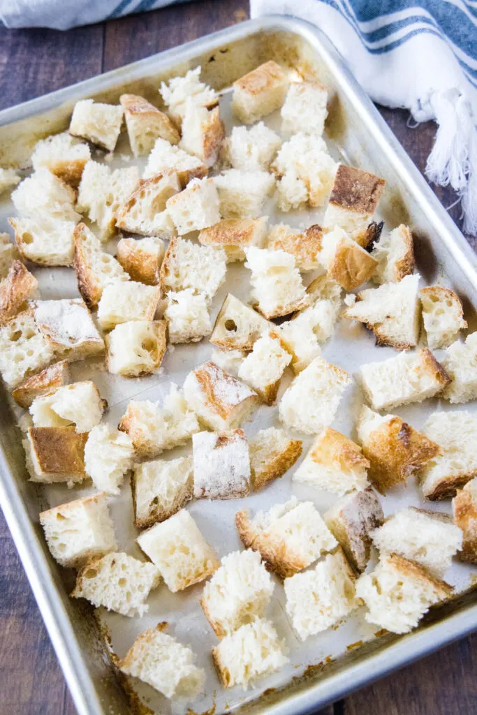 looking down at bread cubes on a baking tray