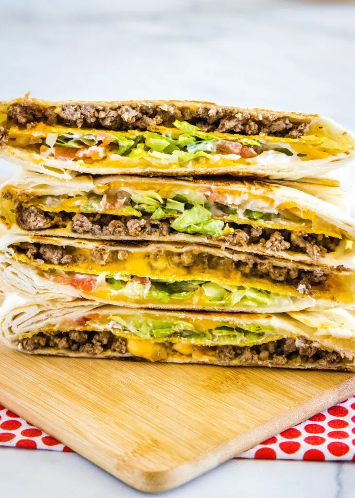 crunchwrap supreme copycat cut in half and stacked on cutting board