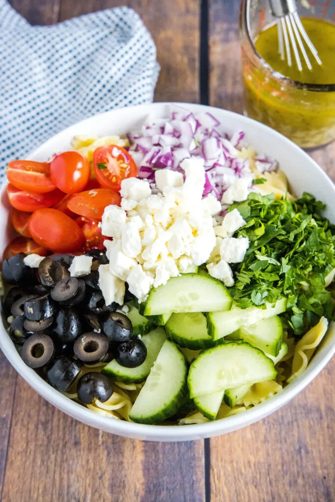 toppings for greek pasta salad arranged in a bowl