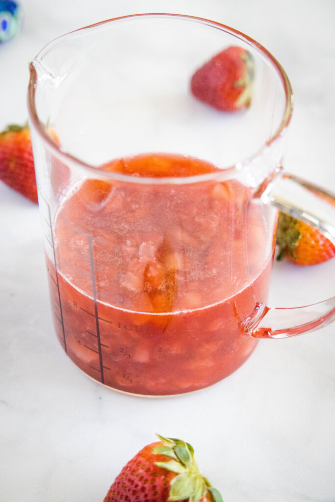 strawberry syrup in a measuring cup