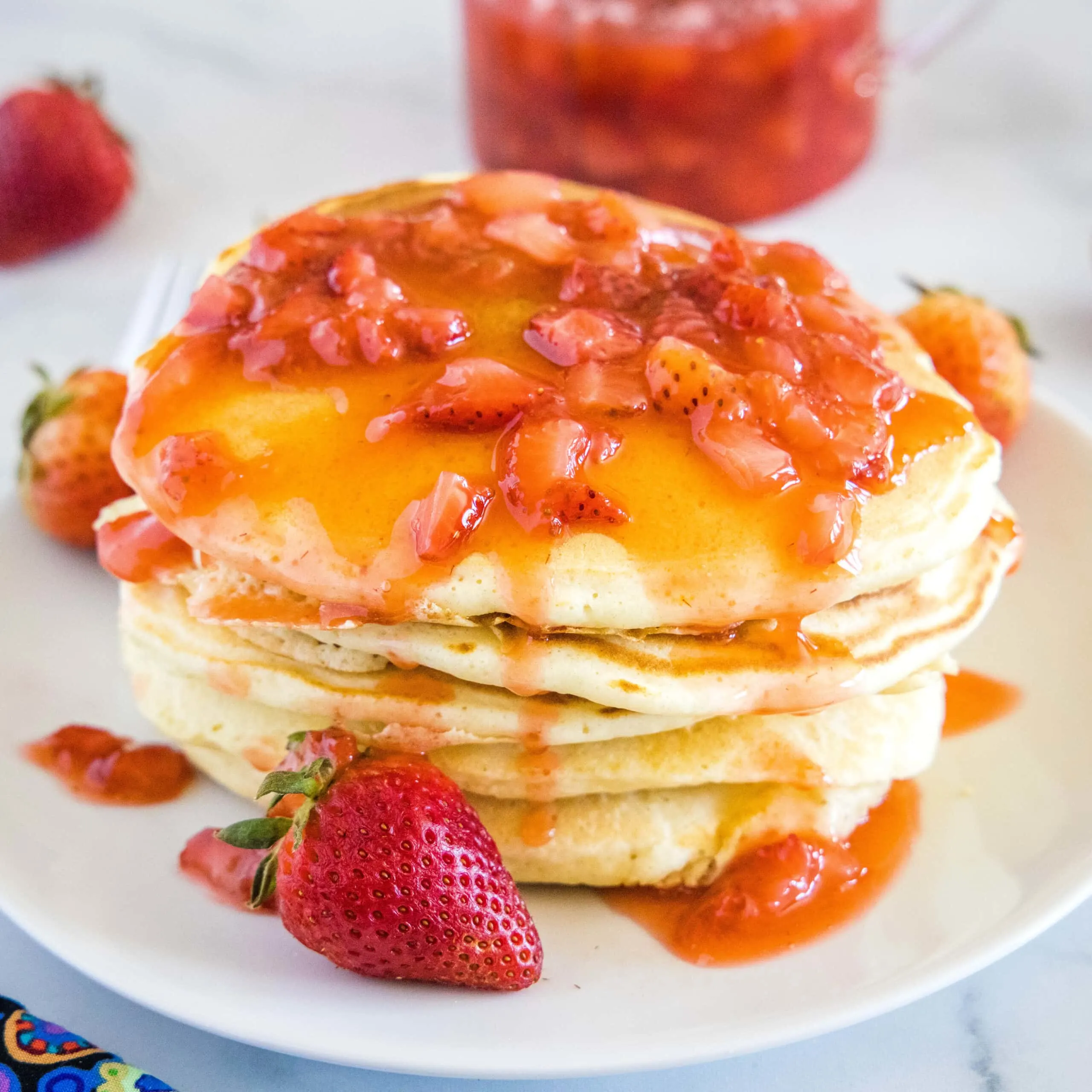 close up stack of pancakes with strawberry sauce