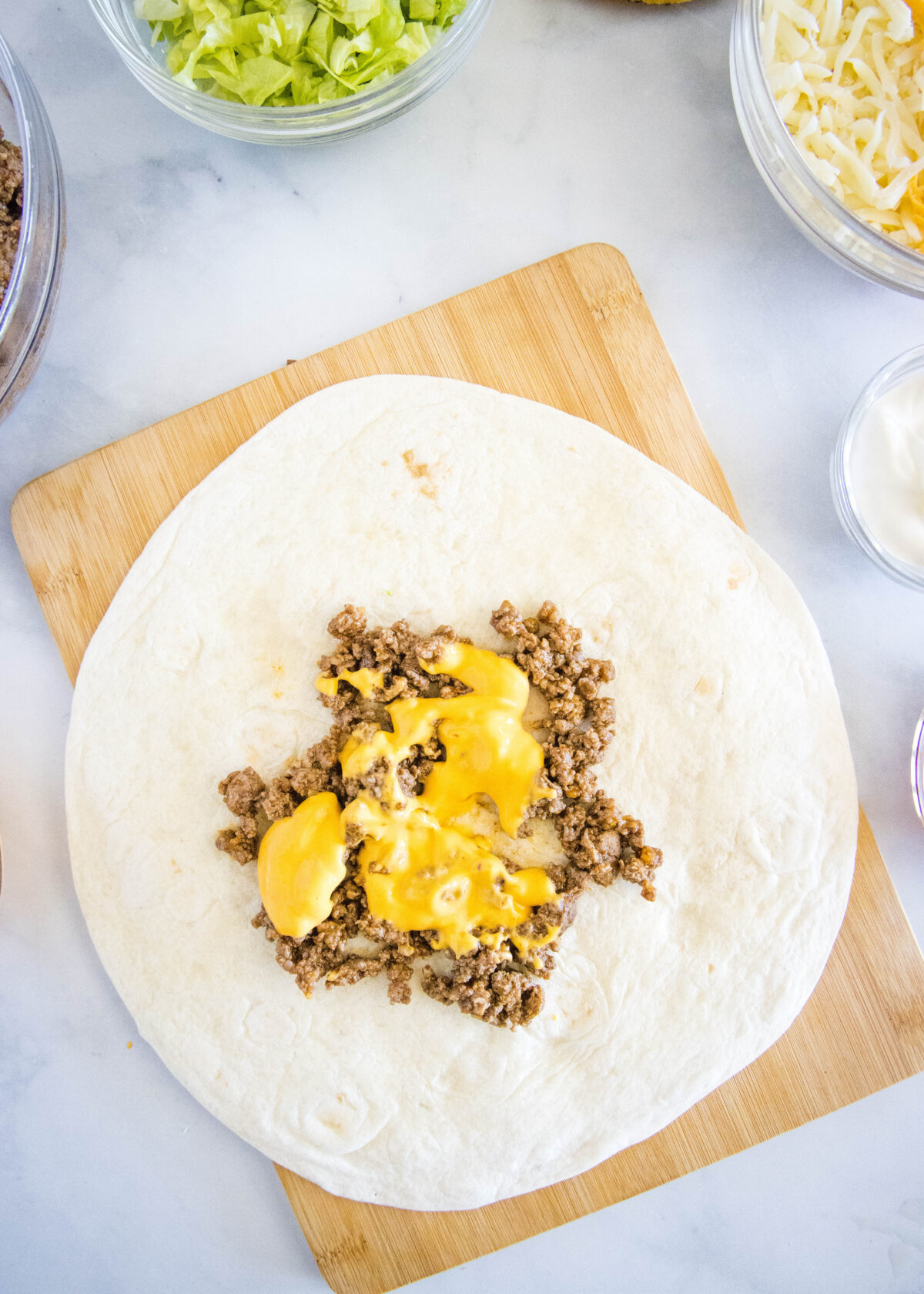 nacho cheese over beef on a tortilla