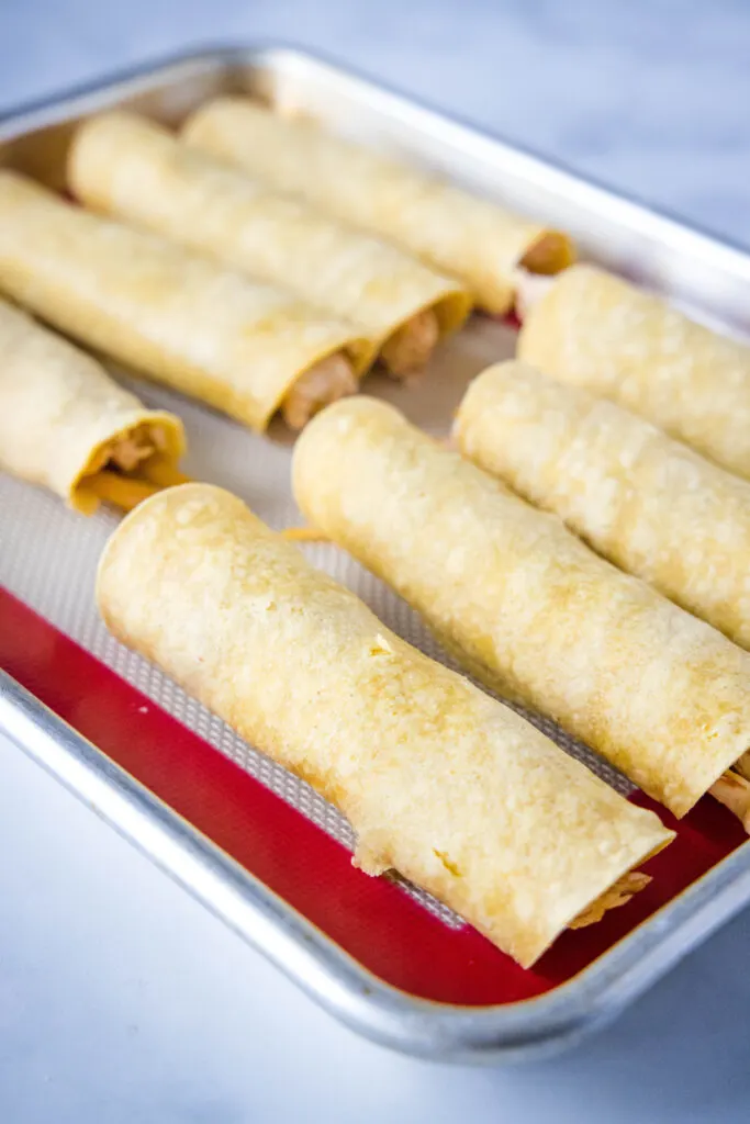 rolled taquitos on baking sheet