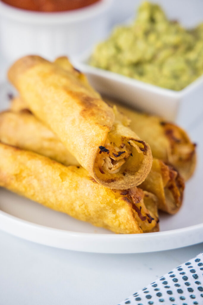 plate with stacked chicken taquitos