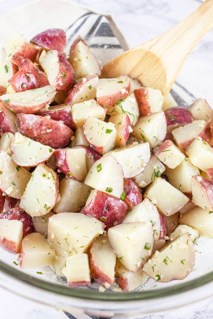 tossing potatoes with lemon dressing