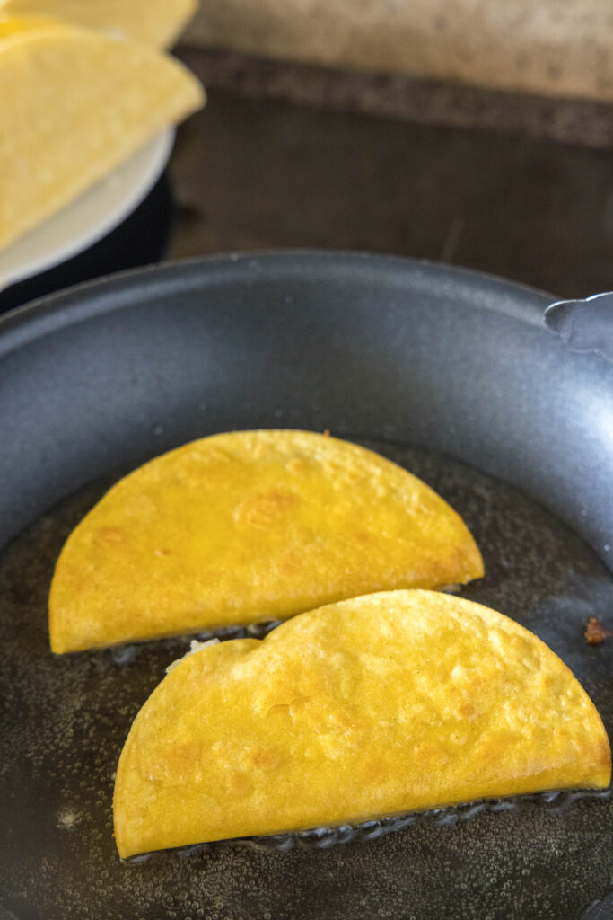 frying tacos in a skillet with oil