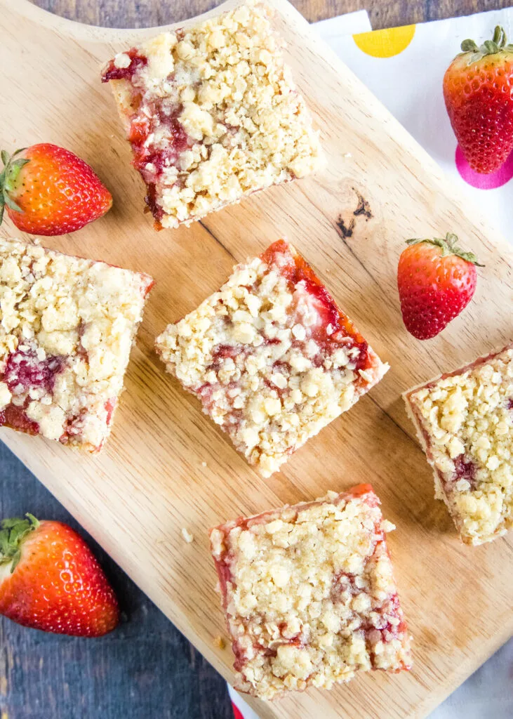 looking down on strawberry crumb bars on a cutting board