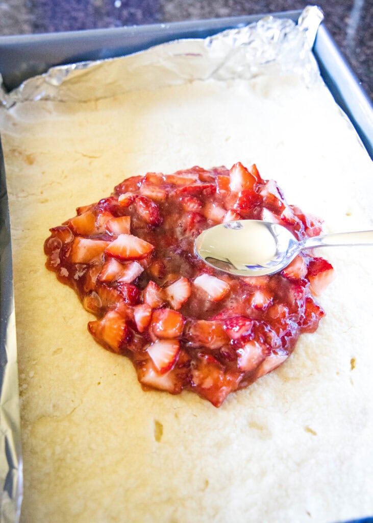 spreading strawberry filling on to bars