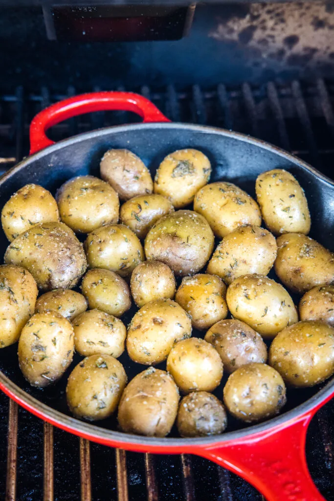 a pan of potatoes on the smoker