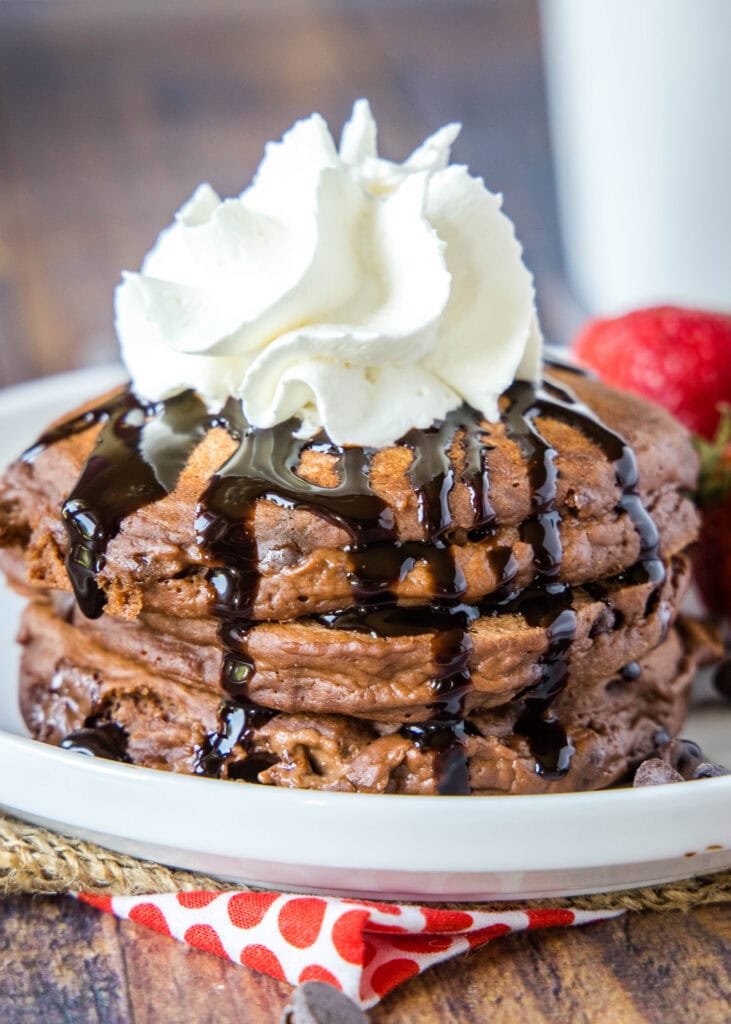 plate of stacked chocolate pancakes on white plate