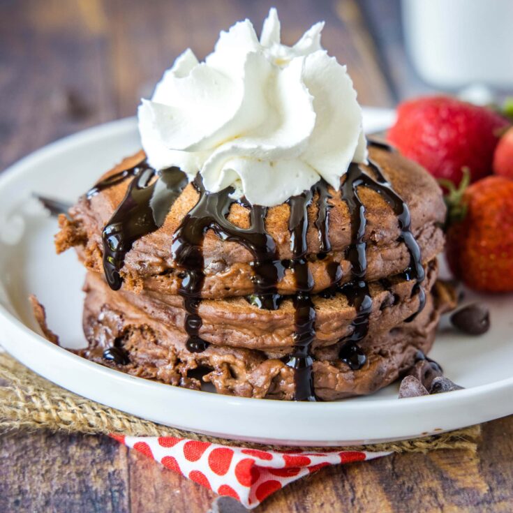 cropped chocolate pancakes picture with chocolate sauce and whipped cream