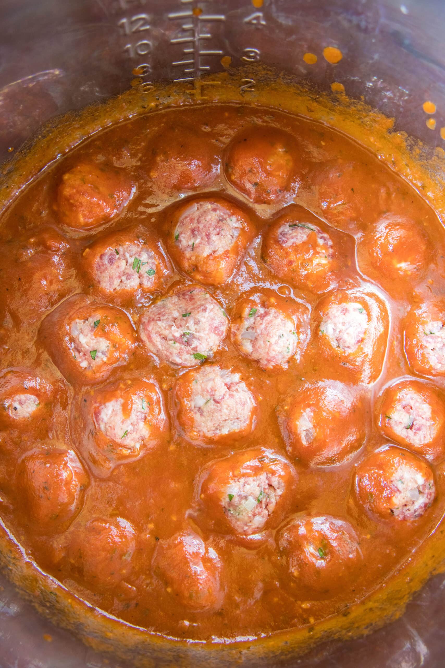 arranging meatballs in instant pot with marinara sauce