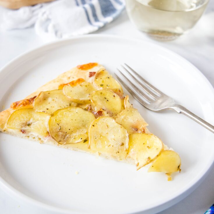 close up slice of pizza with sliced potatoes