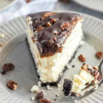 close up slice of turtle cheesecake with bite on a fork