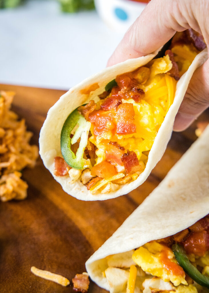 holding a breakfast taco like you are ready to take a bite