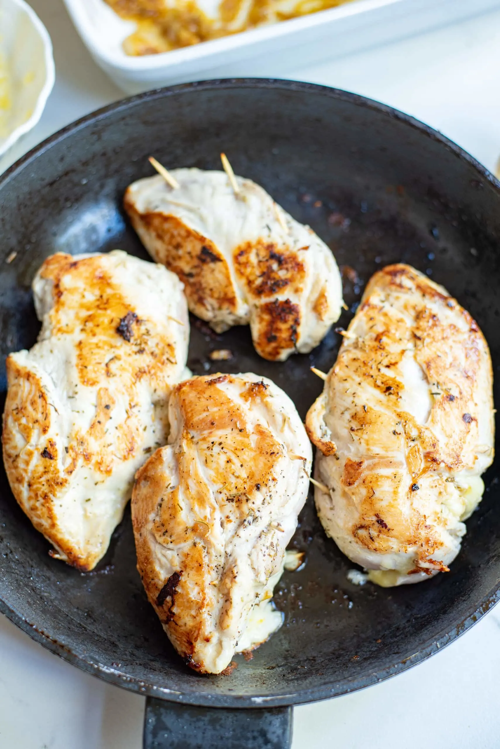 searing stuffed chicken in a skillet