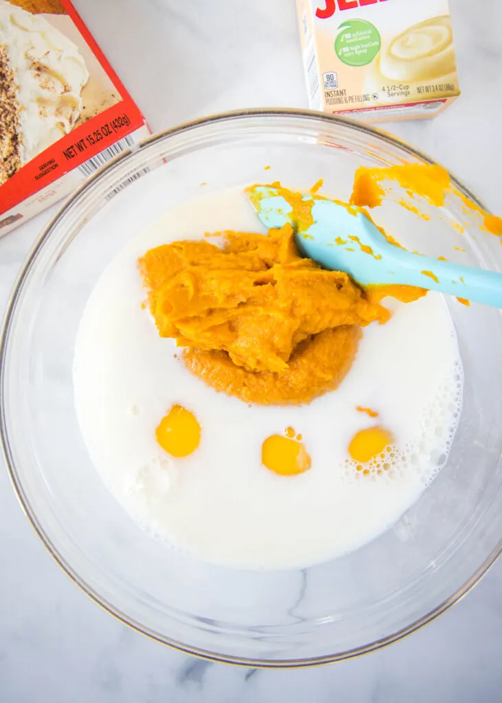 pumpkin, milk and eggs in a mixing bowl