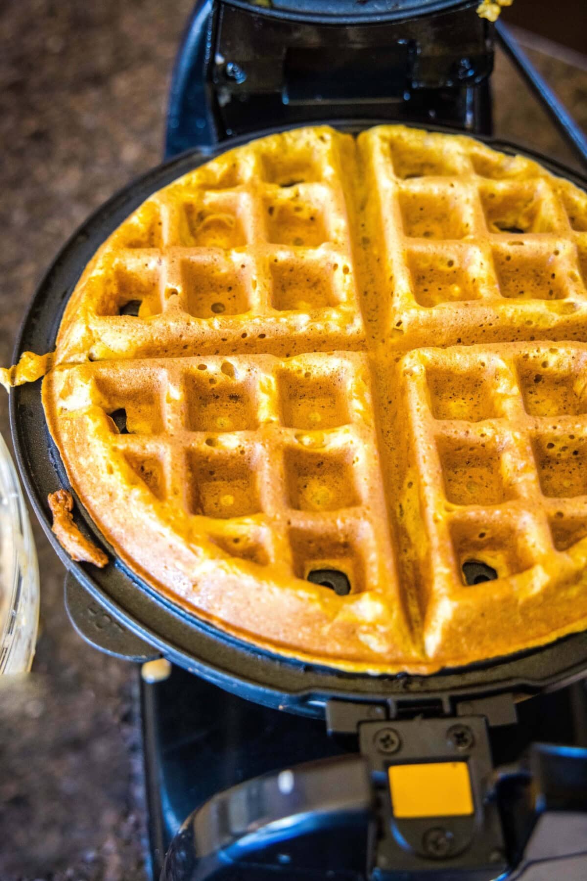 pumpkin waffle cooking in waffle iron