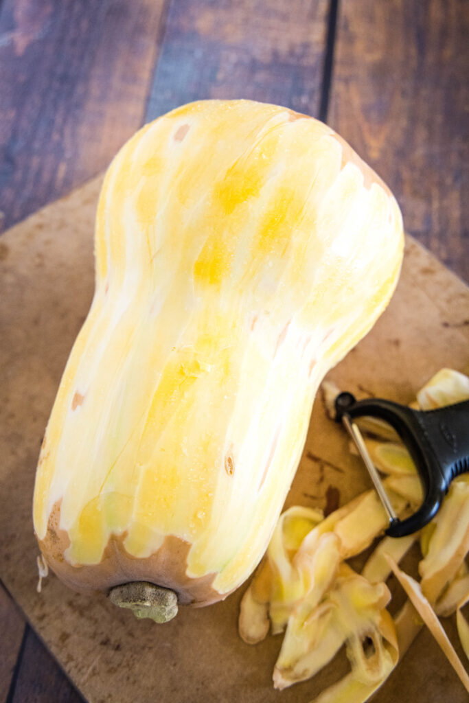 peeled butternut squash on a cutting board