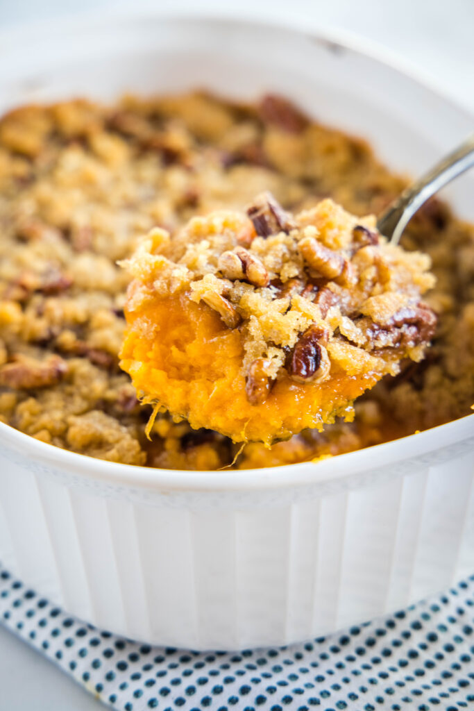 taking a scoop out of the sweet potato casserole dish