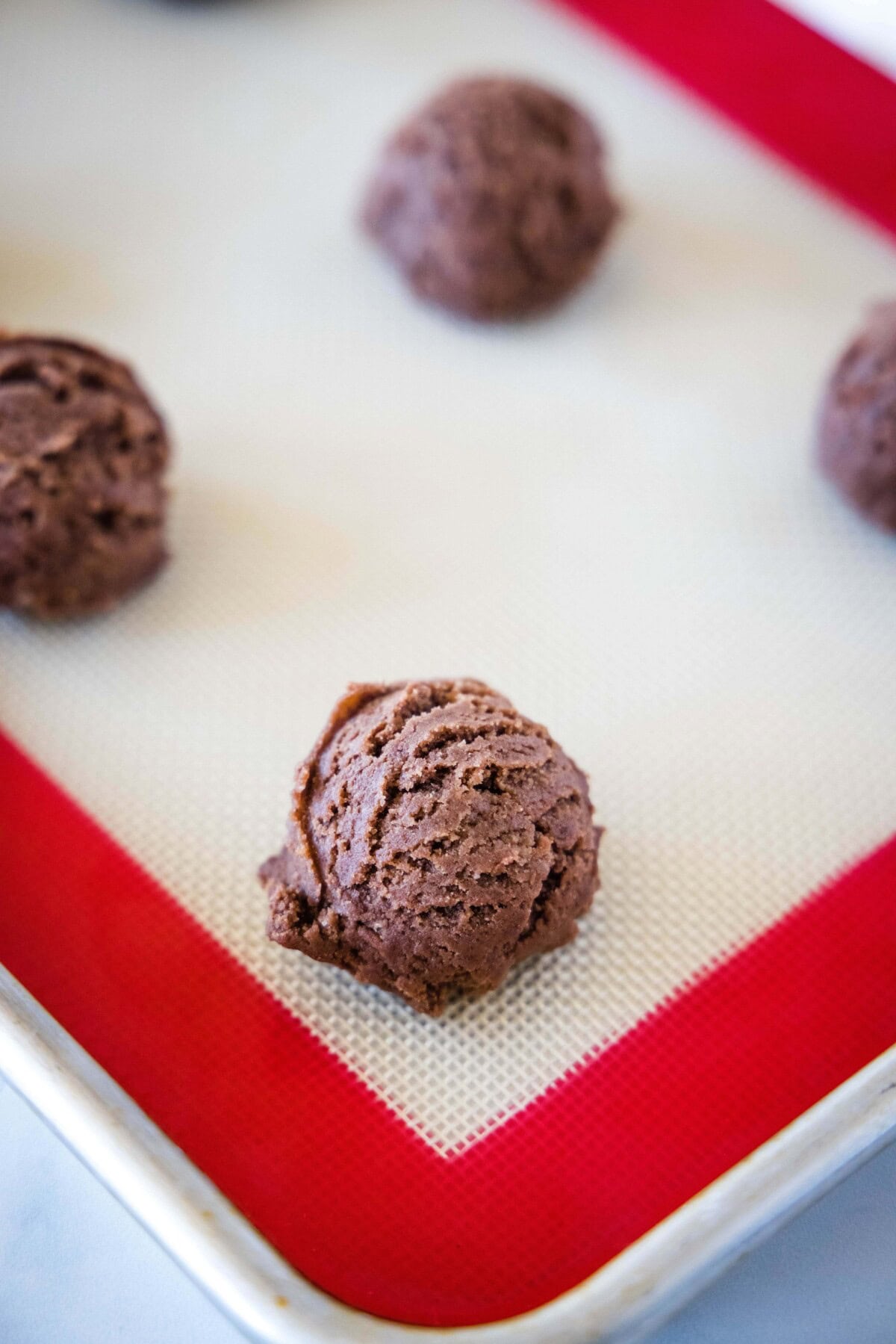 ball of chocolate cookie dough on a baking sheet