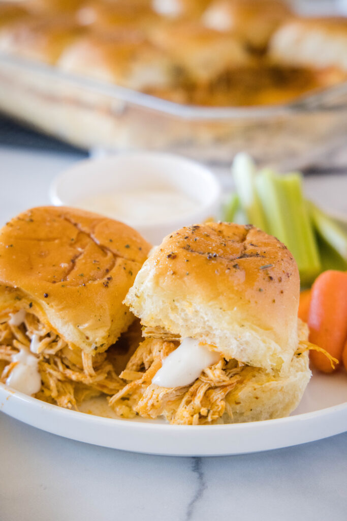 buffalo chicken sliders with ranch dressing on a white plate