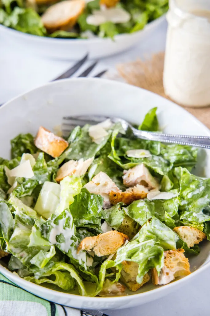 chicken caesar salad in bowl with a fork